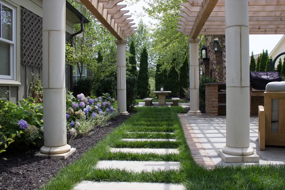 Rectangular stepping stones through grass between porch columns